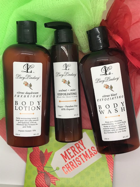 A set of three Christmas-themed body care products including a body lotion, body wash, and another body product, all with festive red and green packaging.